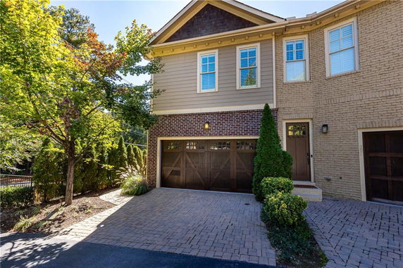 Front view of a two-story house with a single-car garage and brick exterior.