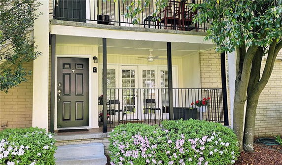 Front view of a house with a small porch and balcony above.
