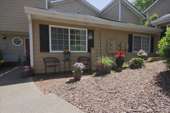 Front view of a single-story house with large windows and potted plants.