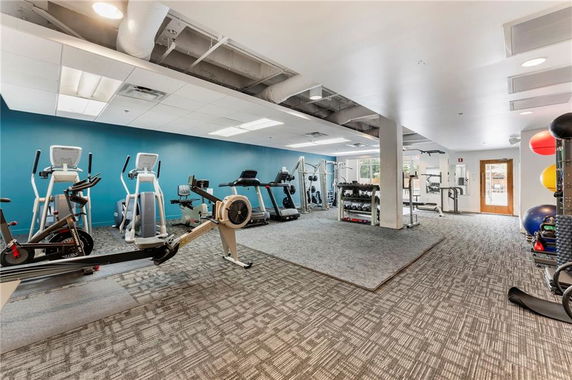 Gym area with various exercise equipment and weights.