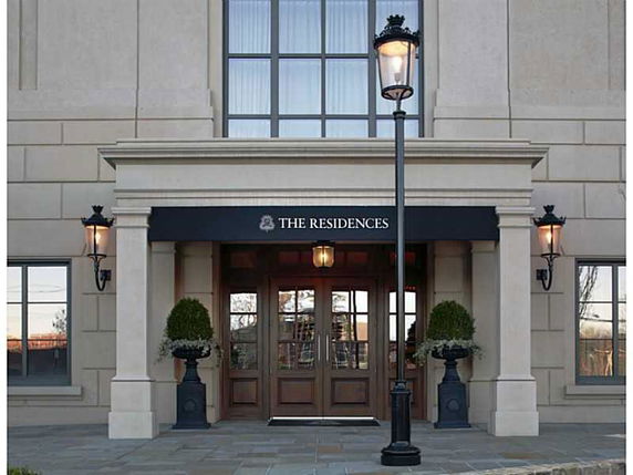 Front view of a building entrance with large glass windows and an awning labeled 'The Residences'.