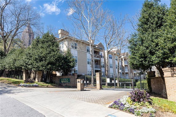 Front view of a multi-story residential building with gated entrance.