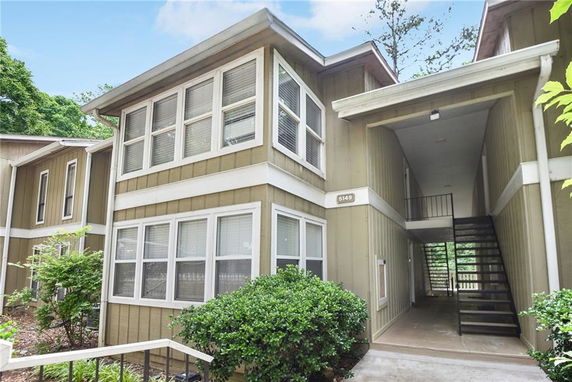 Front view of a modern two-story residential building with large windows.
