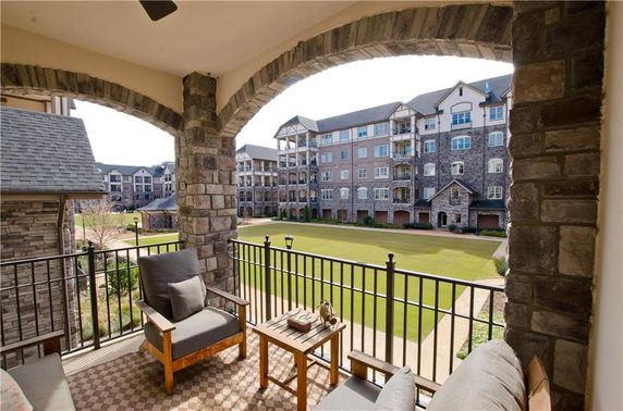View from a balcony overlooking a courtyard and multi-story residential buildings.