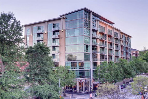 Front view of a multi-story building with glass balconies.