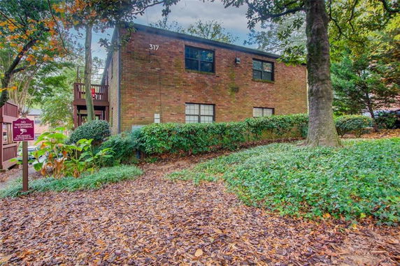 Front view of a two-story brick building with windows and outdoor stairs.