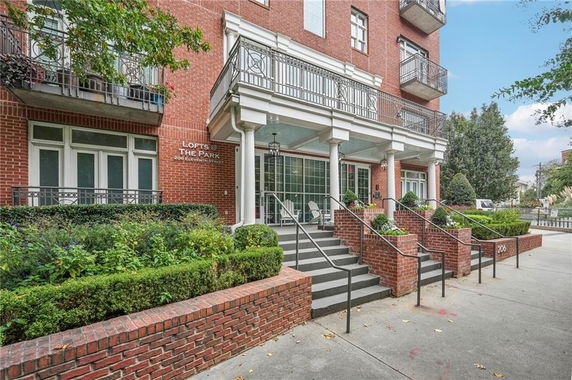 Front view of a multi-story brick building with balconies and a main entrance.