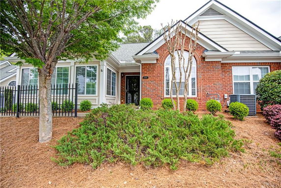 Front view of a brick single-story house with large windows.