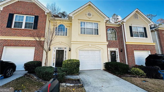 Front view of a two-story townhouse with an attached garage.