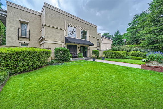 Front view of a two-story house with a flat roof and large windows.