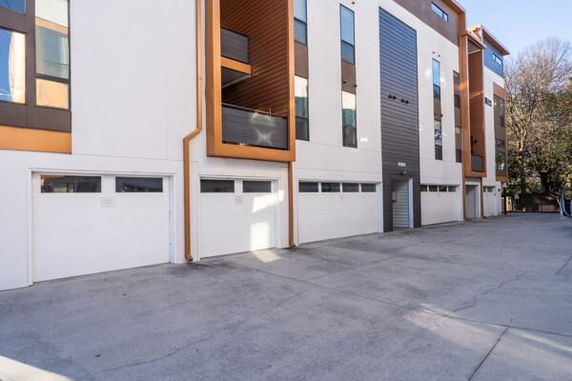 Front view of a multistory building with a series of garage doors.