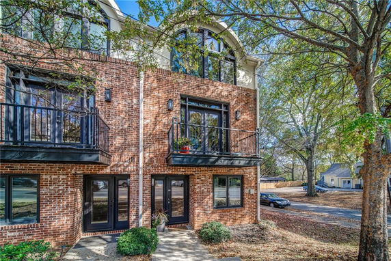 Front view of a multi-story brick house with balconies.