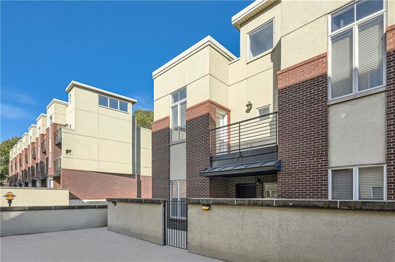 Front view of a multi-story residential building with balconies and a brick exterior.