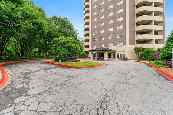Front view of a multi-story apartment building with a driveway.