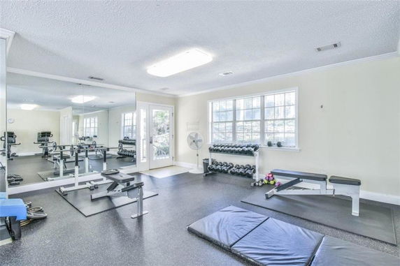 Interior view of a fitness gym with exercise equipment and mirrors.