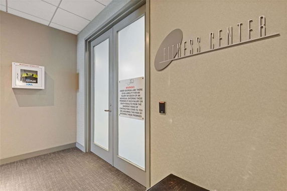 Entrance to a fitness center with a door and sign.