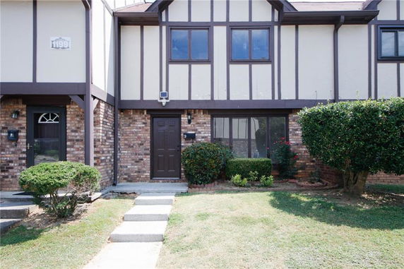 Front view of a two-story townhouse with brick facade and decorative trim.