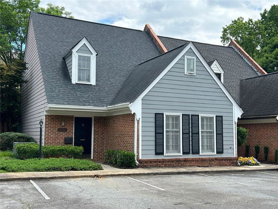 Front view of a house with a steeply pitched roof and dormer windows.