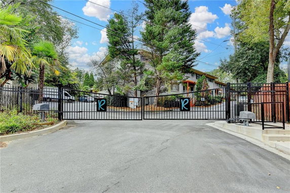 Front view of a multi-story building behind a gated entrance.