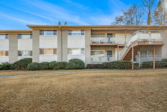 Front view of a two-story residential building with outdoor stairs and balconies.
