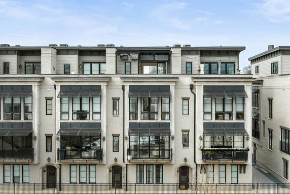 Front view of a multi-story residential building with multiple balconies.