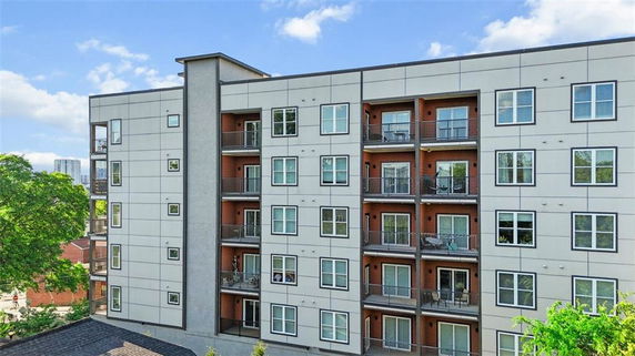 Front view of a multi-story apartment building with balconies.