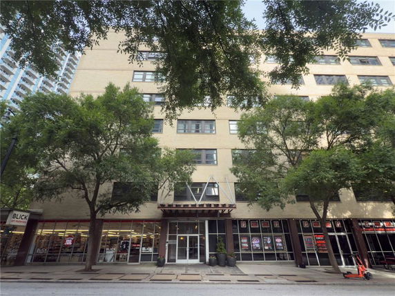 Front view of a multi-story building with large windows and a central entrance.