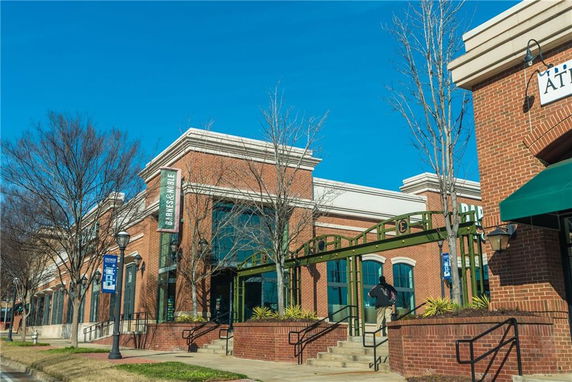 Front view of a brick commercial building with large windows and signage.