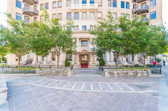 Front view of a multi-story building with a grand entrance and symmetrical design.