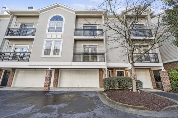 Front view of a modern three-story townhouse with balconies.