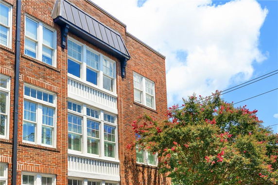 Front view of a multi-story brick building with multiple windows.