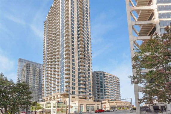 Front view of a tall modern residential building with balconies.