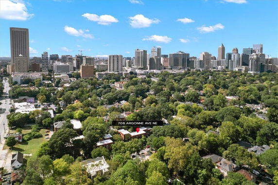 Wide-angle panoramic view of a city skyline with numerous buildings and green areas.