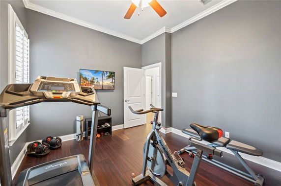 Home gym with exercise equipment including a treadmill and stationary bike.