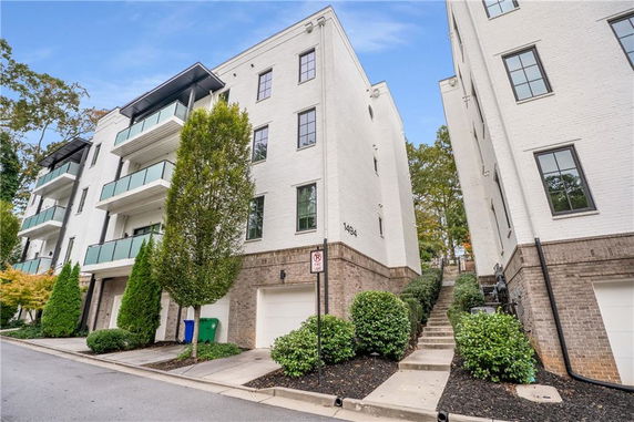 Front view of a multi-story apartment building with balconies.