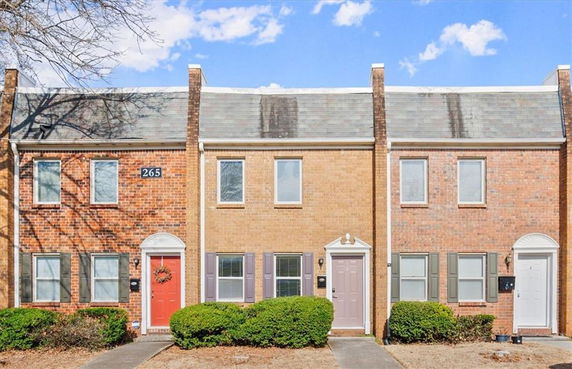 Front view of a row of brick townhouses with multiple entrances.