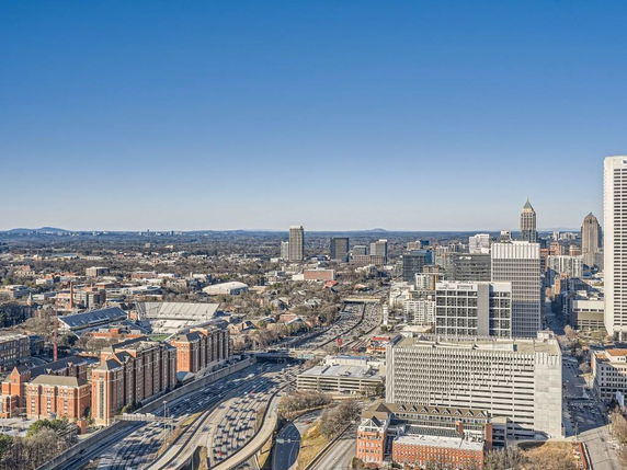 Panoramic view of a cityscape with tall buildings and highways.