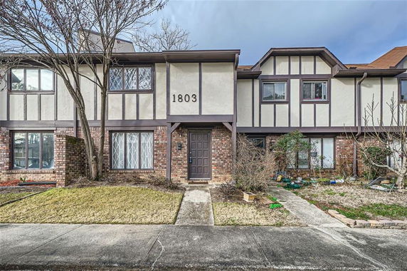 Front view of a two-story townhouse with brick and siding exterior.