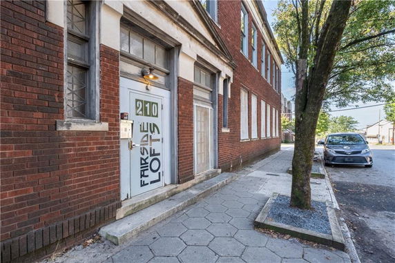 Front view of a brick building with a side entrance labeled 'Fairsidelofts 210'.