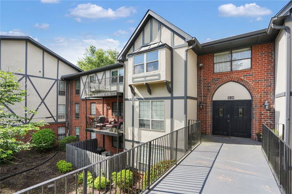Front view of a multi-story residential building with brick and panel facade.