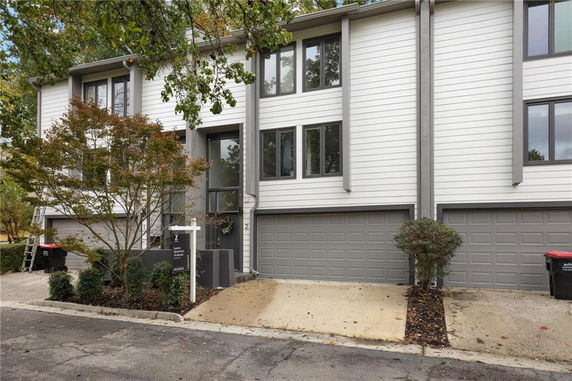 Front view of a townhouse with attached garages and a modern facade.