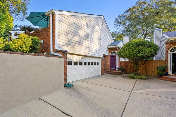Front view of a house with a garage and a sloped roof.