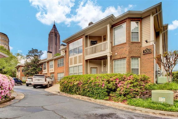 Front view of a two-story building with a porch and brick exterior.