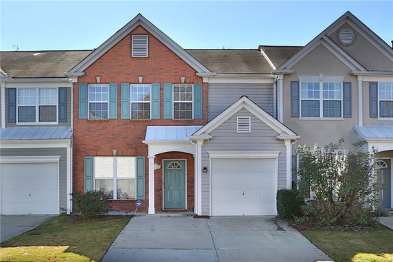 Front view of a two-story townhouse with a brick and siding exterior.