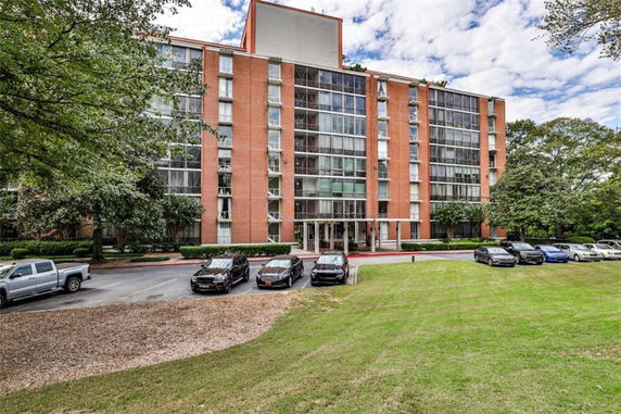 Front view of a multi-story building with large windows and red brick exterior.
