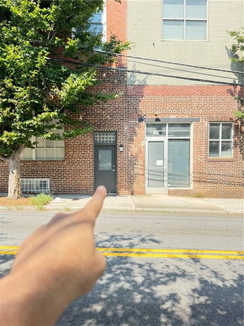 Front view of a brick building with multiple doors and windows.