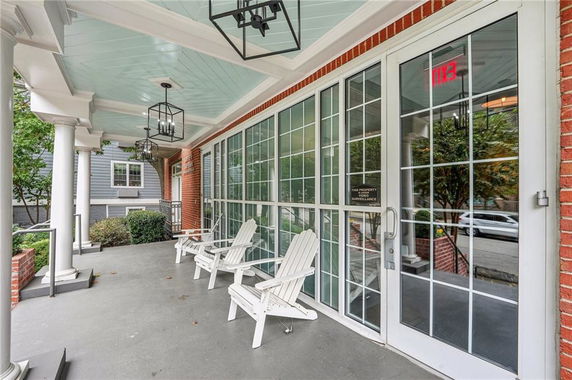 Front view of a house with a covered porch and white framed glass doors.