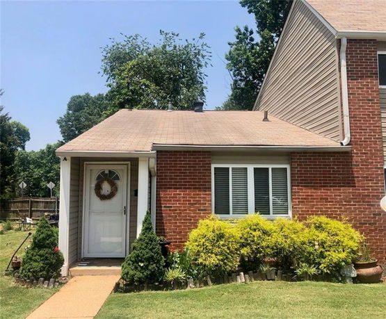 Front view of a brick single-story house with a small porch.