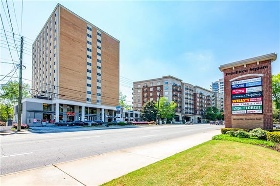 Front view of a multi-story commercial building with retail signs.