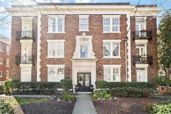 Front view of a multi-story brick building with decorative elements and balconies.